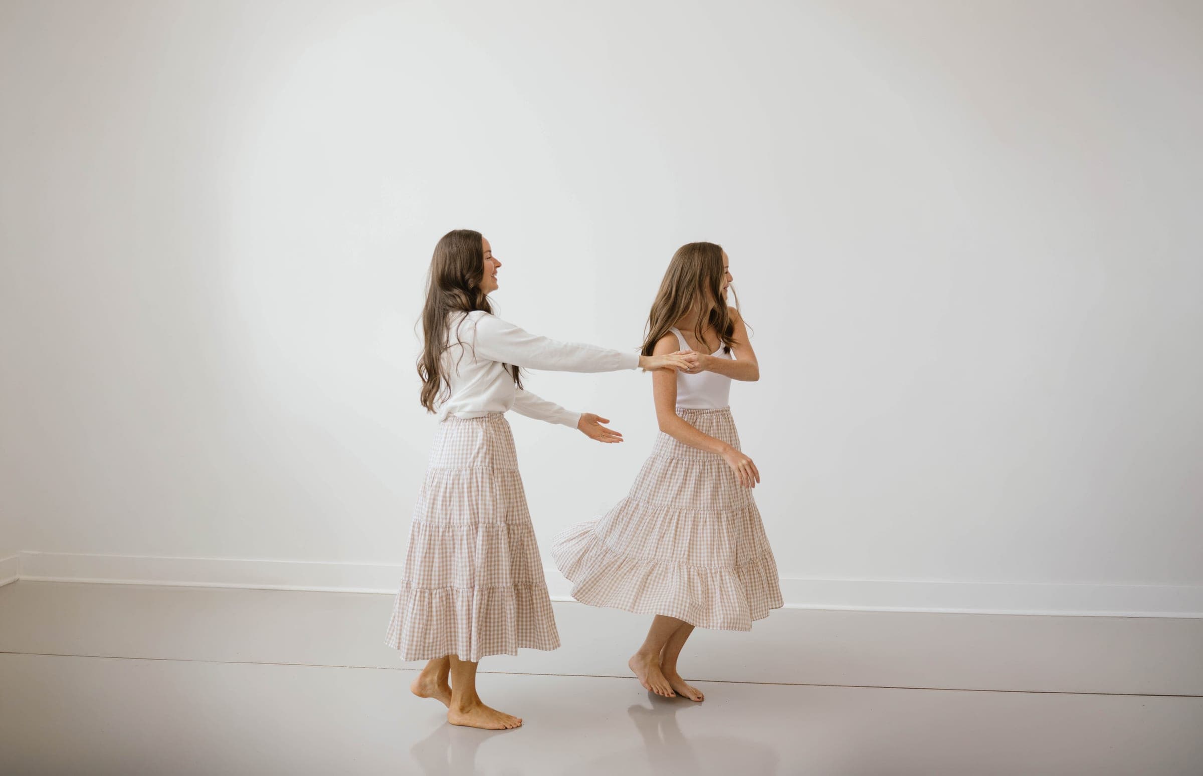 Two girls twirling in cotton dresses
