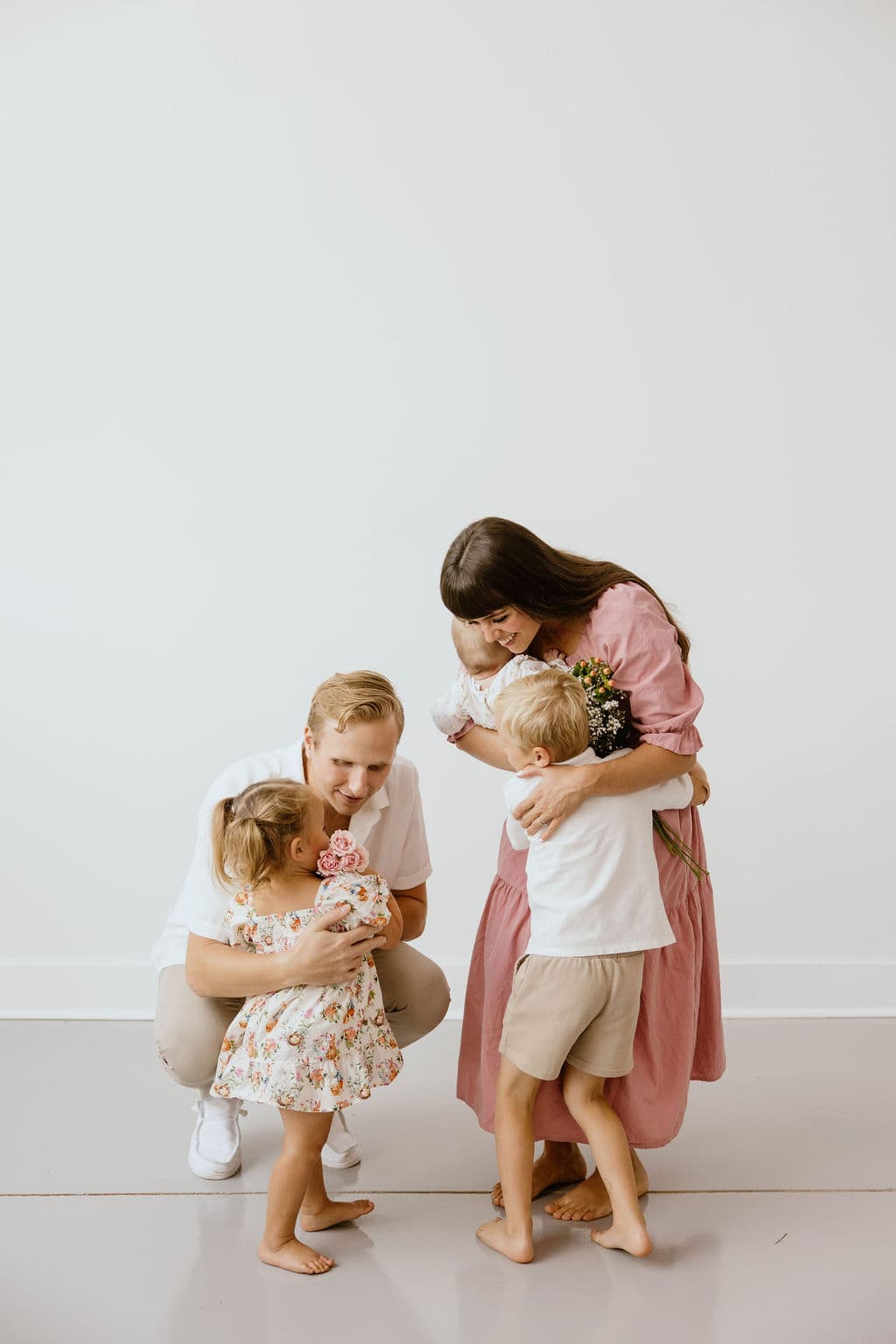 A mother in a cotton dress embracing her child